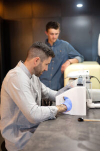 Patient watching Oculus Prosthetics Ocularist polish his hand crafted artificial eye.