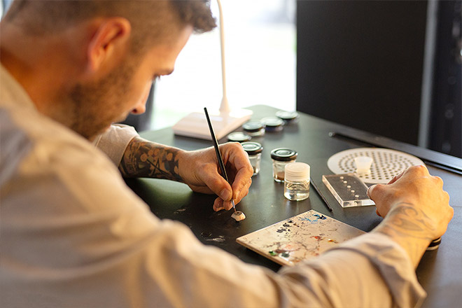 Ocularist hand painting a prosthetic eye