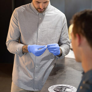 Ocularist Dwayne Collins inspecting his patients new prosthetic eye.