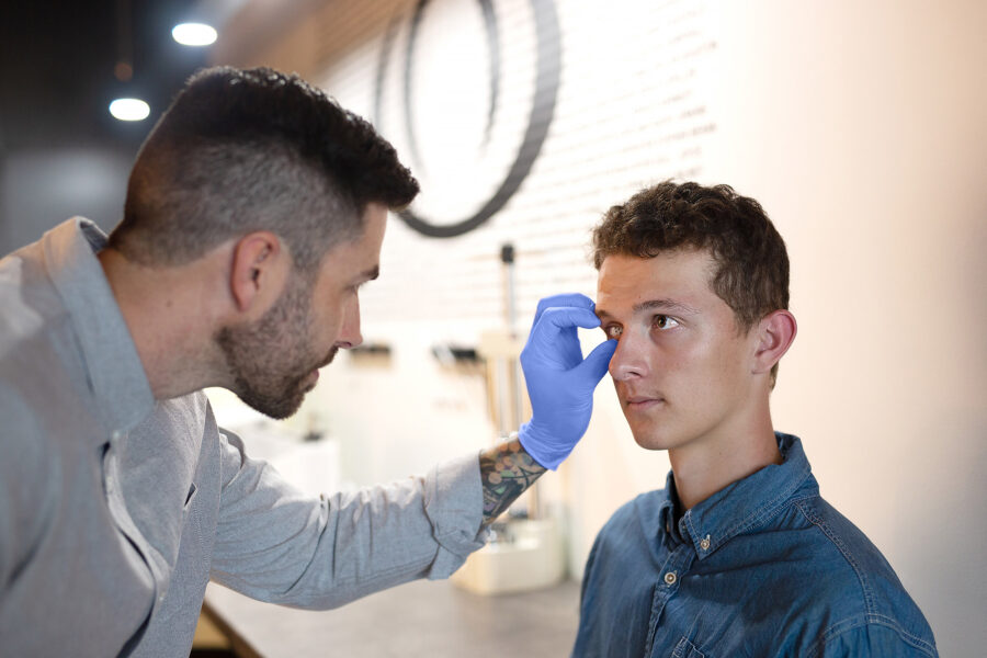 Ocularist Dwayne Collins inserting an artificial eye into a patient’s eye socket